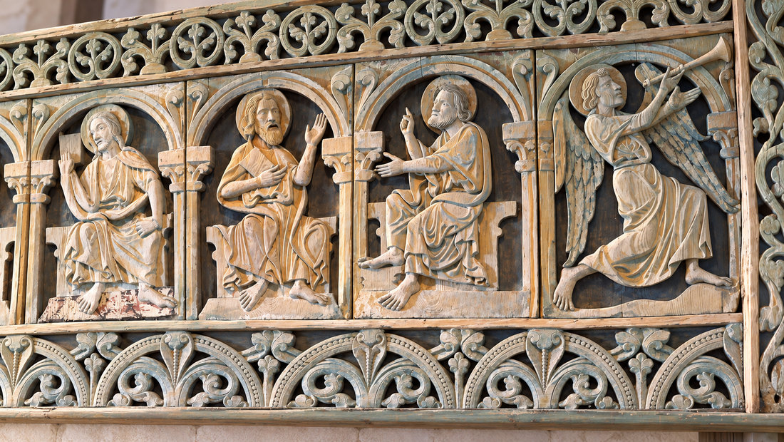 Et illustrert sideutsnitt av tregalleriet i Kinn kirke, med utskårne apostler og en engel.